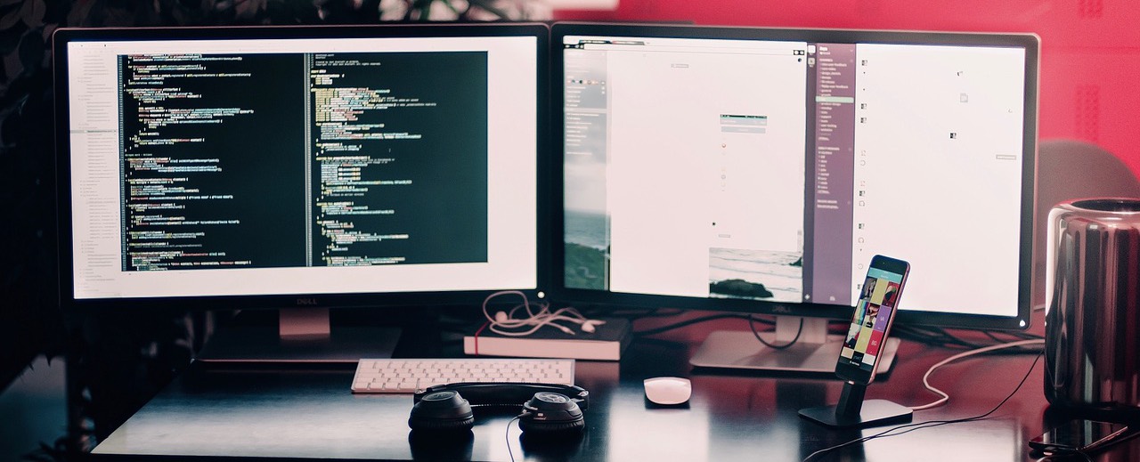 A developer workstation with code open across two monitors